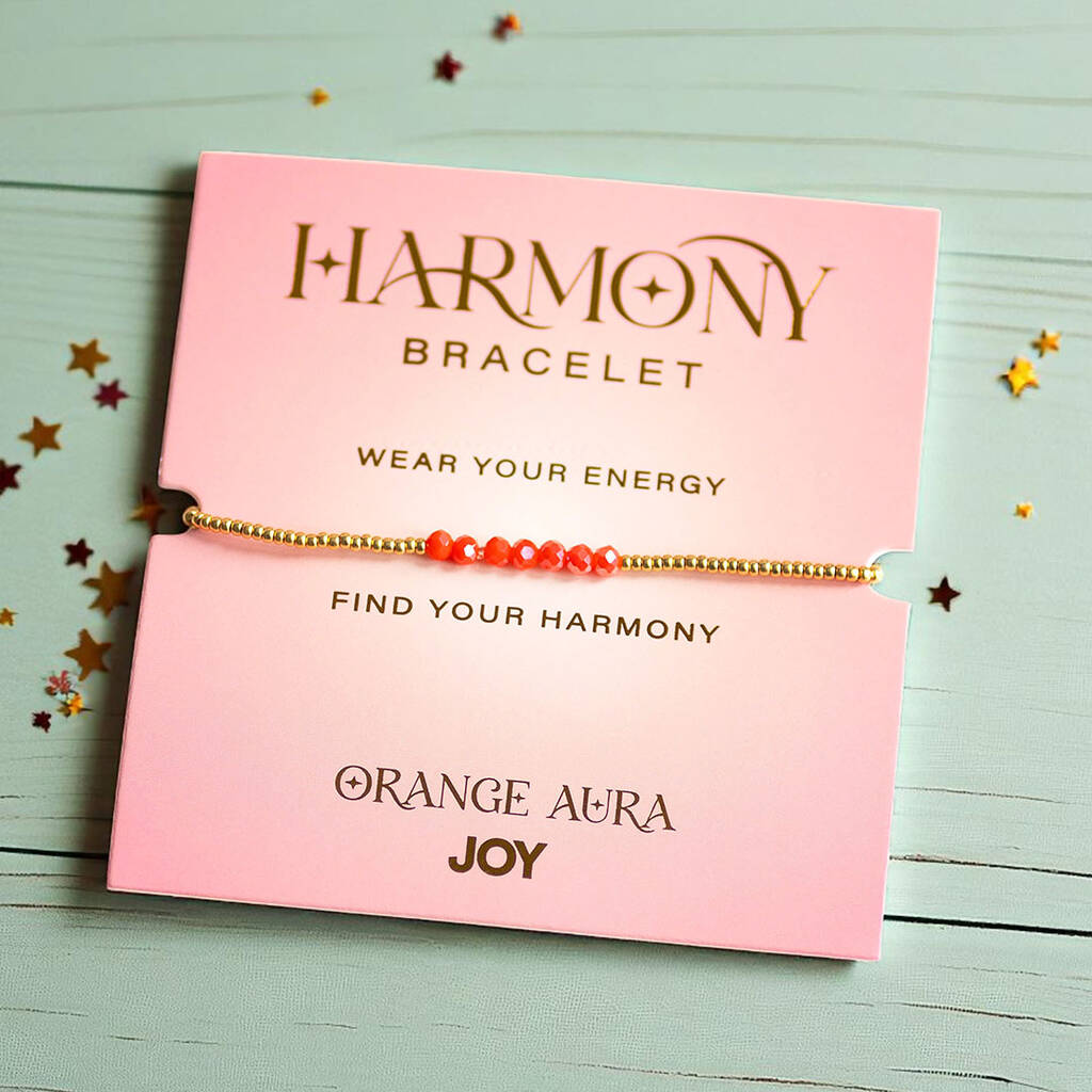 Orange Aura Joy bracelet with gold beads, displayed on pink card reading 'Find Your Harmony' and 'Wear Your Energy
