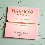Orange Aura Joy bracelet with gold beads, displayed on pink card reading 'Find Your Harmony' and 'Wear Your Energy