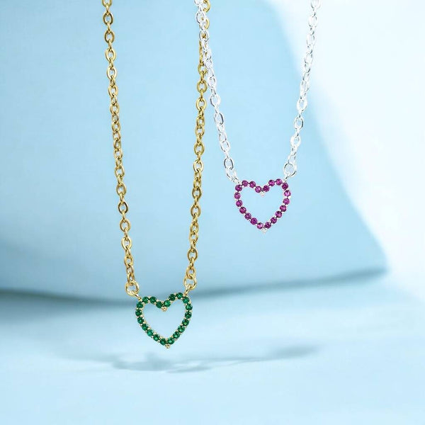 Green and pink crystal heart birthstone necklaces in gold and silver tones, perfect for colourful everyday styling.
