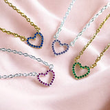 Colourful crystal heart necklaces with blue, purple, pink and green stones, styled on gold and silver-tone chains.
