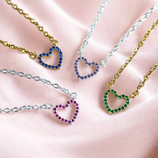 Colourful crystal heart necklaces with blue, purple, pink and green stones, styled on gold and silver-tone chains.
