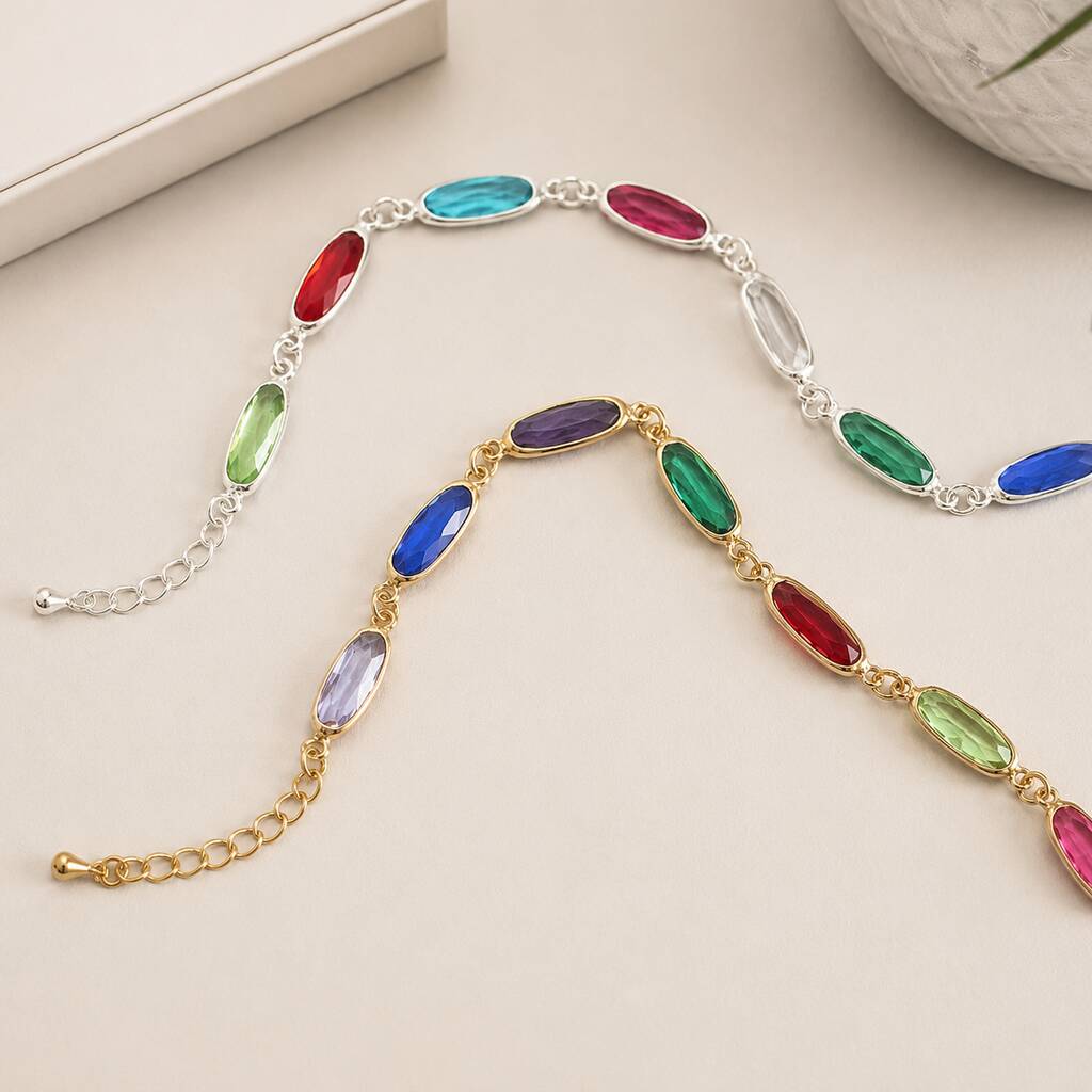 Gold and silver oval link birthstone bracelets with colourful crystal details, modern personalised stacking jewellery.