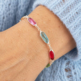 Silver oval link birthstone bracelet with pink, blue and red crystal details, elegant everyday layering jewellery.