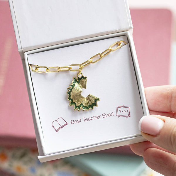 Gold plated charm bracelet with a hanging gold with green trim pencil sharping charm, presented in a gift box on a Best Teacher Ever sentiment card.