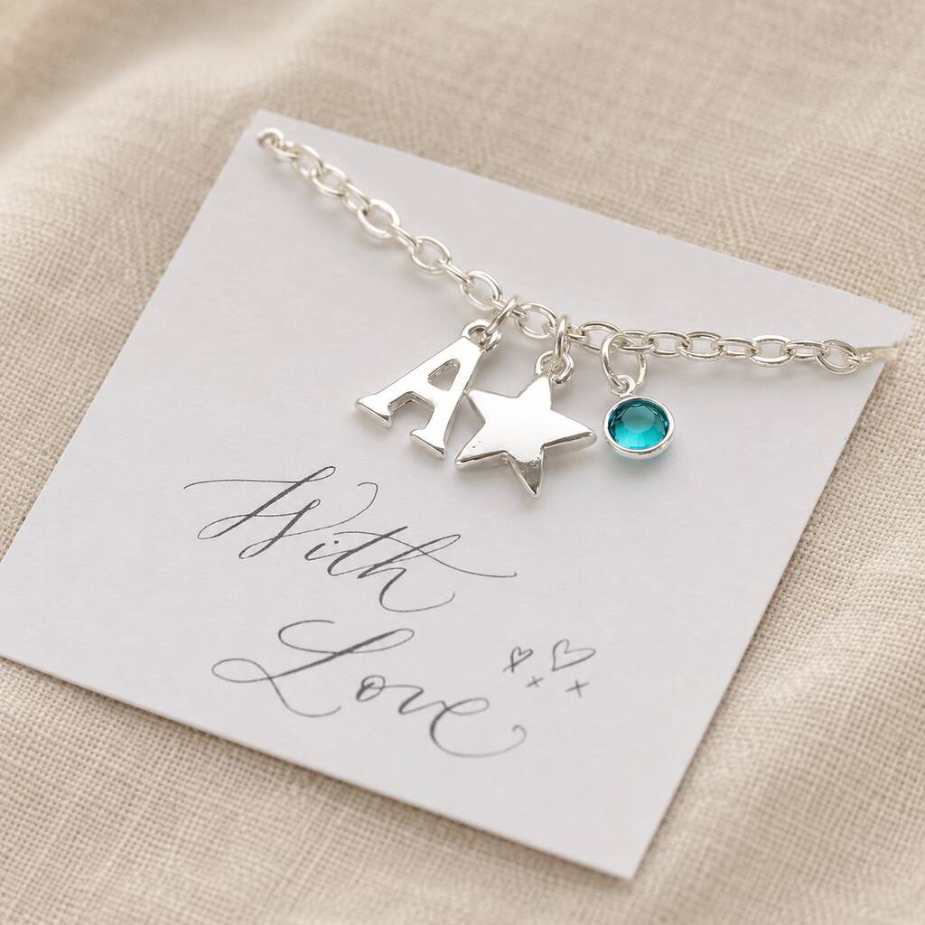 Silver children's charm bracelet with letter A, star pendant and blue birthstone presentation card