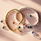 Family birthstone Mama charm bracelet featuring custom birthstones for children in silver and gold