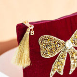 Luxury velvet pouch with hand-beaded bow design, crystal detail and JOY embroidery showing the personalised intital B