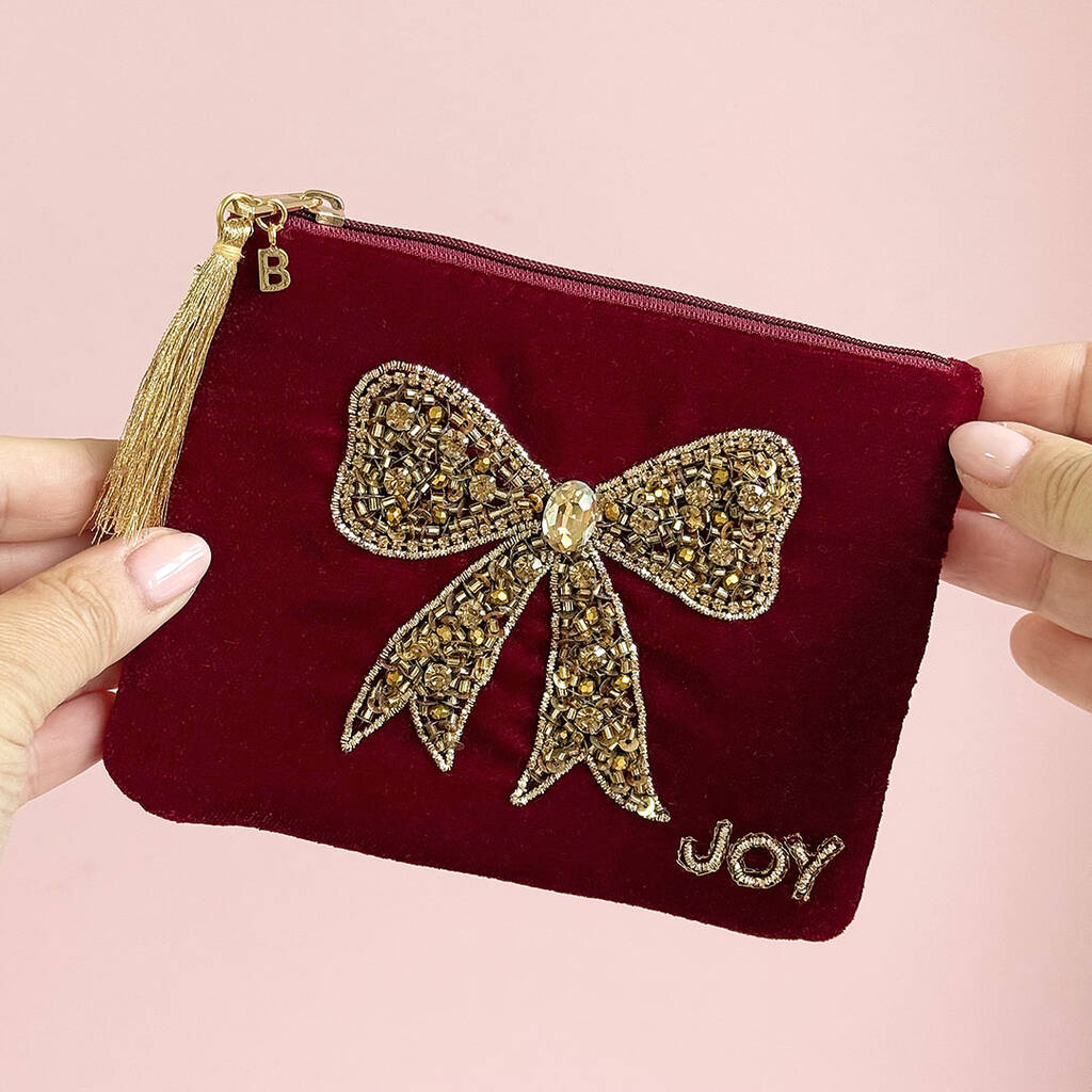 Red velvet pouch with gold bow beading, tassel zip charm and personalised initial tag