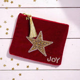 Velvet pouch in jewel tone fabric with gold star beading, tassel zip and personalised initial charm