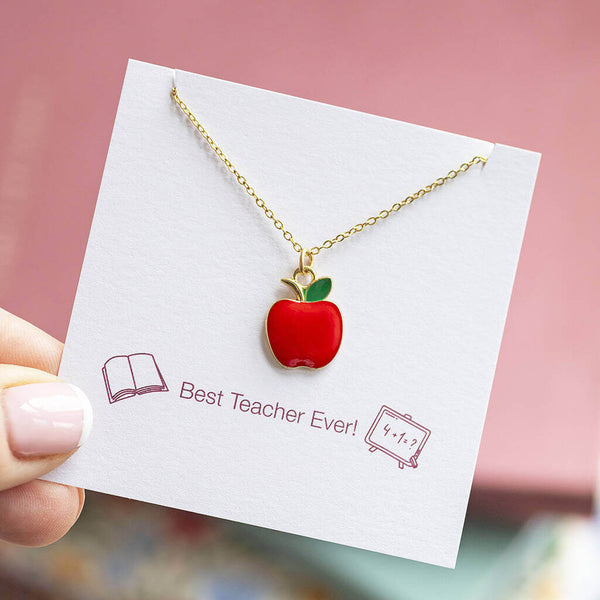 Gold necklace with a red enamel apple charm suspended on chain and presented on a Best Teacher Ever sentiment card