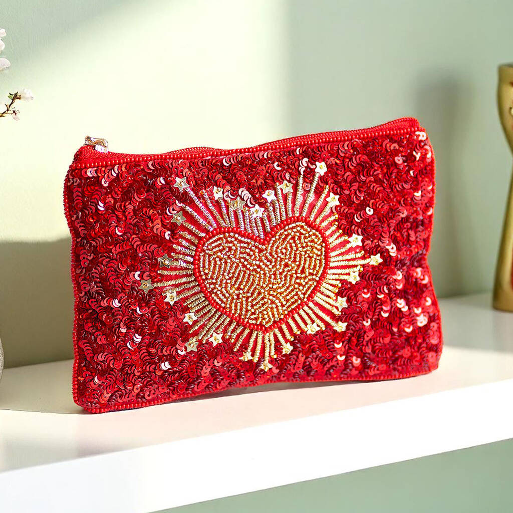 Red fabric pouch decorated with gold beaded heart, finished with a personalised gold initial charm on the zip.