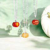 Silver red agate gemstone pumpkin necklaces shown in a variety of shades suspended from a jewellery stand.