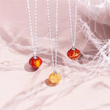 Three silver red agate gemstone pumpkin necklaces.