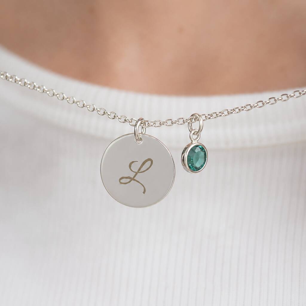 Silver plated script initial disc necklace with a teal birthstone charm, a timeless personalised everyday necklace