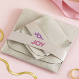 Image shows JOY branded suedette pouches in two sizes on a pink backdrop.