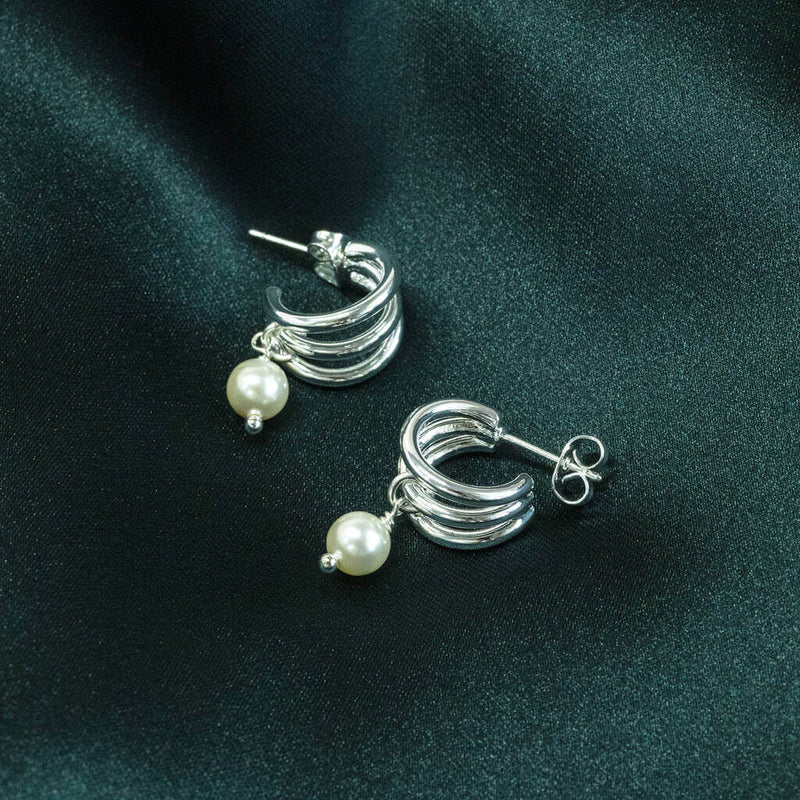 Image shows Silver Plated Triple Hoop Pearl Earrings on a green backdrop