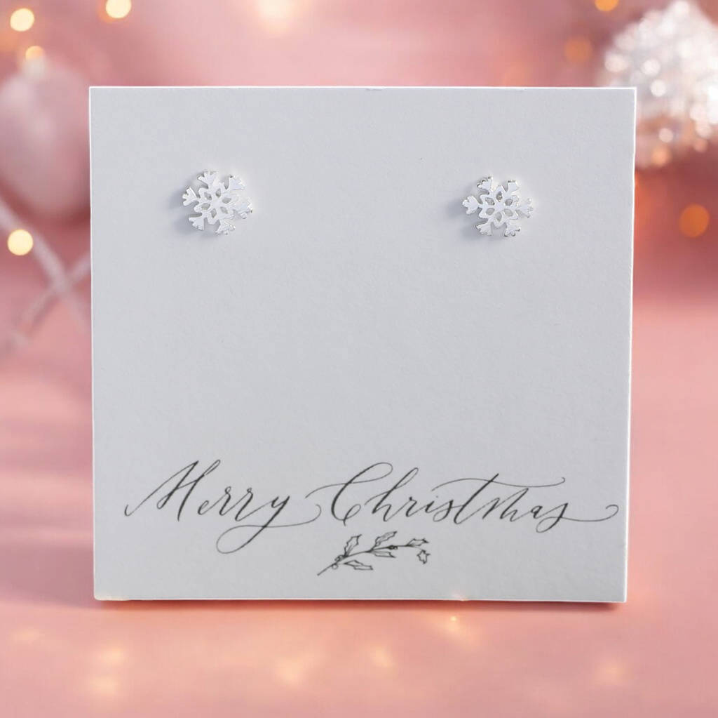 Image shows silver plated snowflake charm stud earrings presented on a Merry Christmas sentiment card.