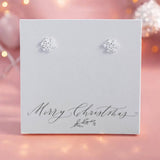 Image shows silver plated snowflake charm stud earrings presented on a Merry Christmas sentiment card.