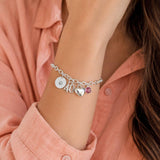 Silver charm bracelet styled with an initial disc, 40 charm, heart charm and pink crystal birthstone