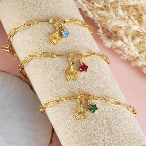 Image shows three gold plated star charm bracelet with birthstone star. From top to bottom: March birthstone star, July birthstone star and May birthstone star.