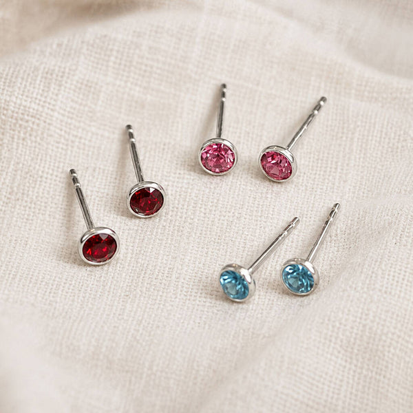 Colourful sterling silver birthstone studs in red, pink and blue, perfect for a bright minimalist ear stack.