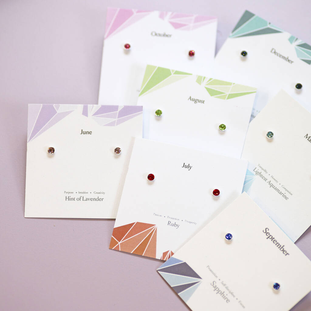 Colourful sterling silver birthstone studs in ruby, sapphire and other shades, displayed on monthly jewellery cards.
