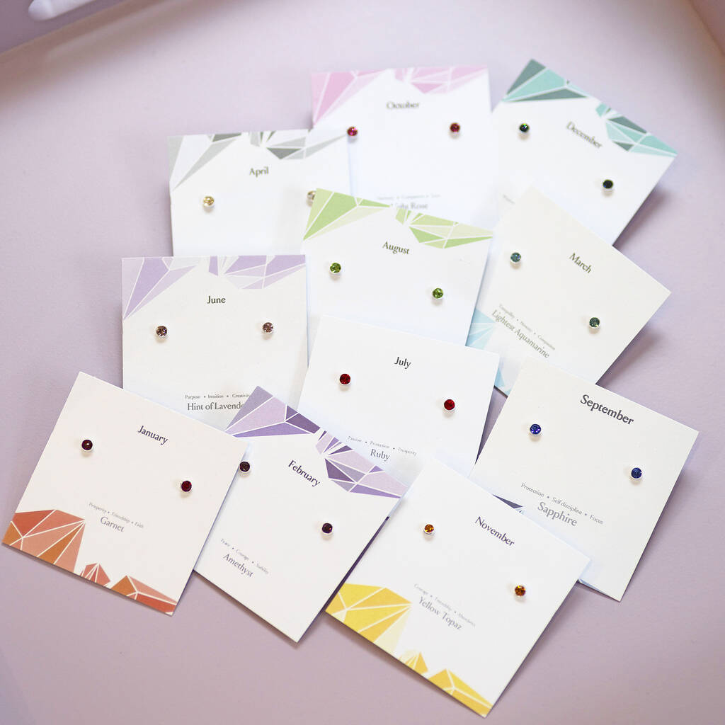 Rainbow birthstone stud earrings in sterling silver, arranged on colourful month cards from January to November.
