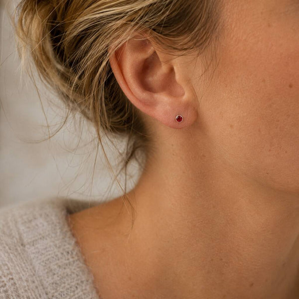 Minimalist sterling silver birthstone stud with a deep red stone, adding a tiny pop of colour to everyday ears.
