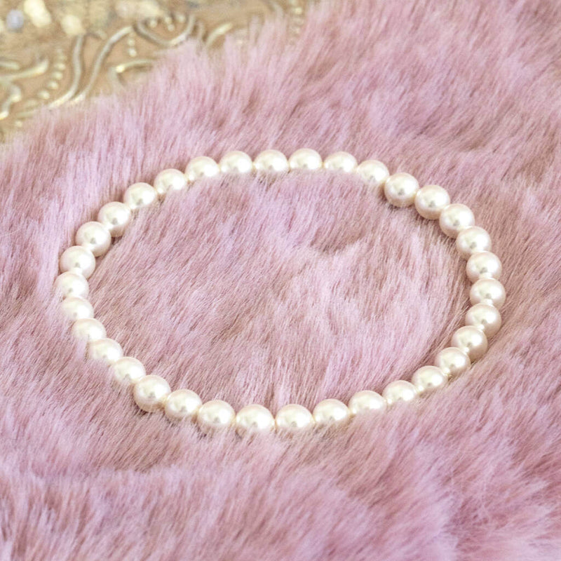 Image shows Stretch Pearl Stacking Bracelet on a pink backdrop.
