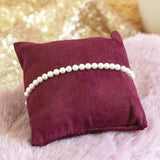 Image shows Stretch Pearl Stacking Bracelet on a maroon jewellery pillow.