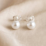 Classic Swarovski pearl stud earrings with luminous white pearls, perfect for everyday styling and layering