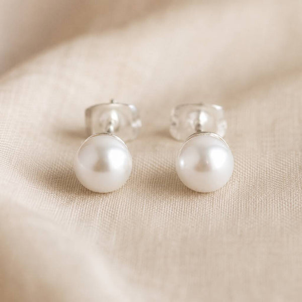 Classic Swarovski pearl stud earrings with luminous white pearls, perfect for everyday styling and layering