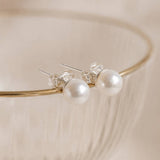 Classic white Swarovski pearl stud earrings with a polished finish, ideal for everyday jewellery styling