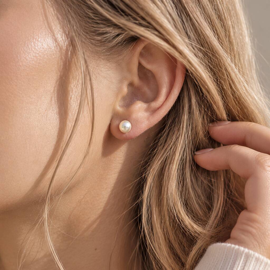 Classic Swarovski pearl stud earrings styled in a pierced ear, perfect for everyday wear and elegant layering looks