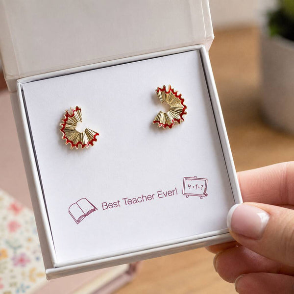 Gold pencil shaving stud earrings displayed in a gift box on a Best Teacher Ever sentiment card