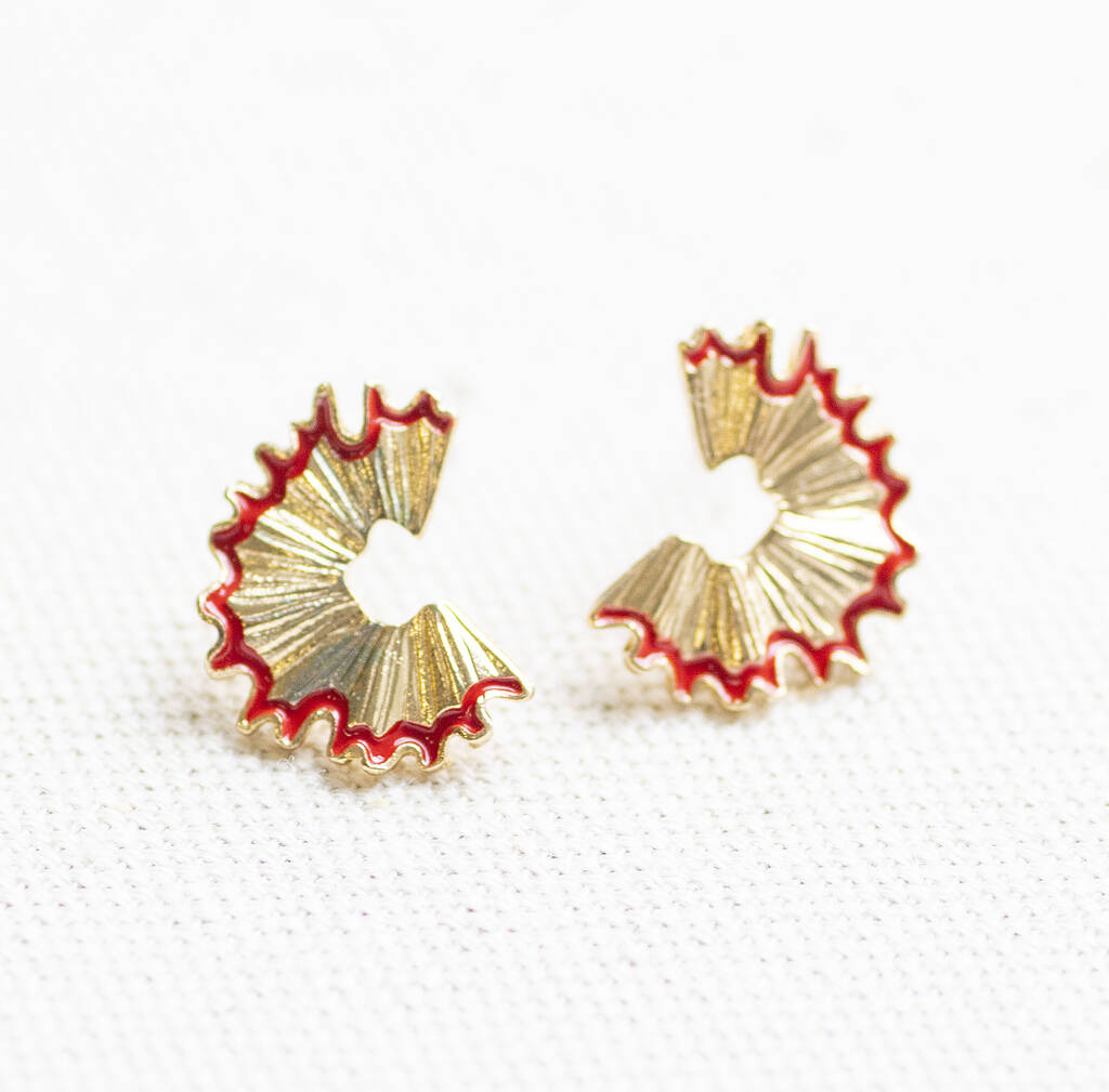 Close-up of gold pencil shaving stud earrings with red enamel detail, playful statement earrings for everyday styling