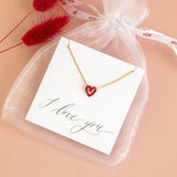 Image shows gold plated Tiny Red Enamel Floating Heart Necklace on an 'I love you' sentiment card with a white organza bag.