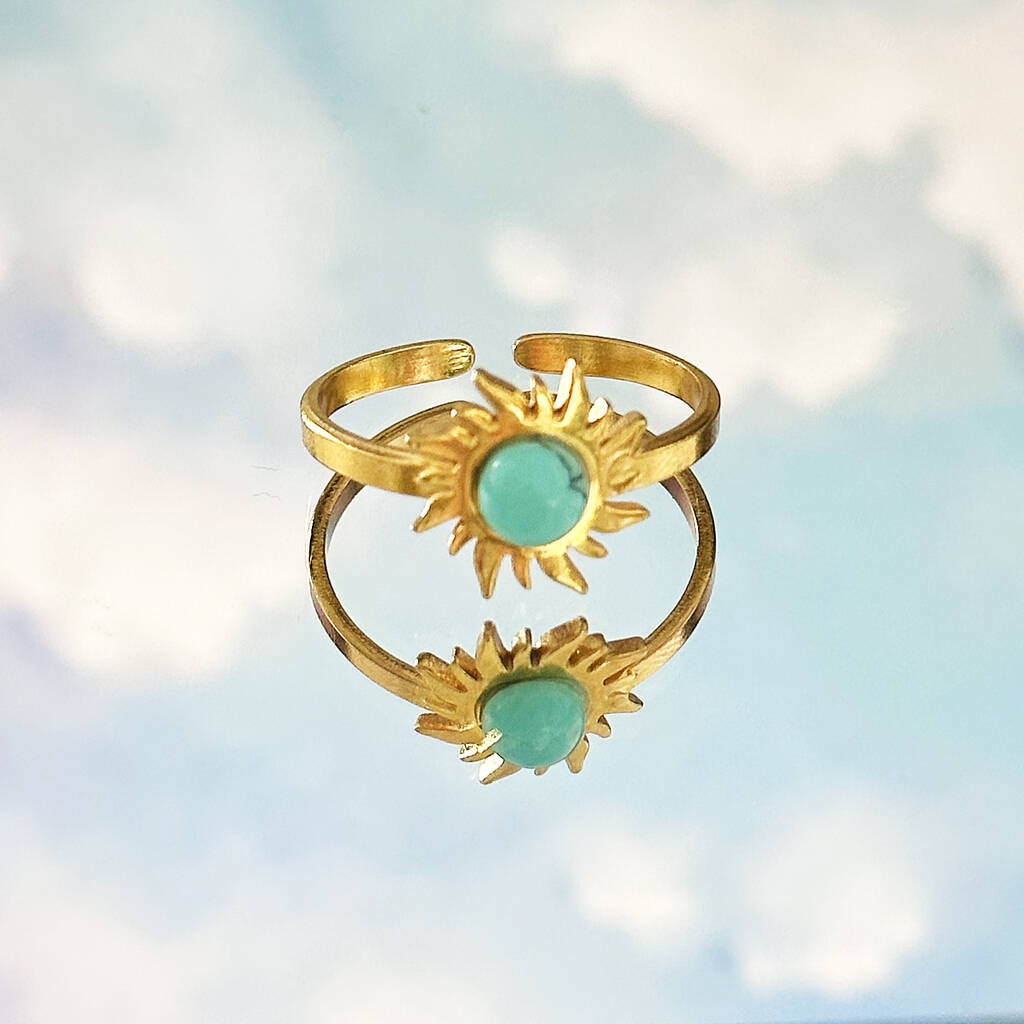 Image shows turquoise gemstone sun ring on a cludy sky background