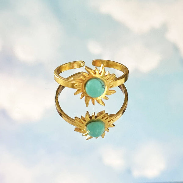 Image shows turquoise gemstone sun ring on a cludy sky background