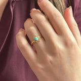 Image shows model in burgundy blouse wearings a turquoise gemstone sun ring