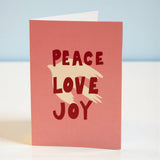 Card with 'Peace Love Joy' text on a light blue background