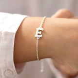 Models wears the personalised pearl initial bracelet on a silver chain with the pearl initial E