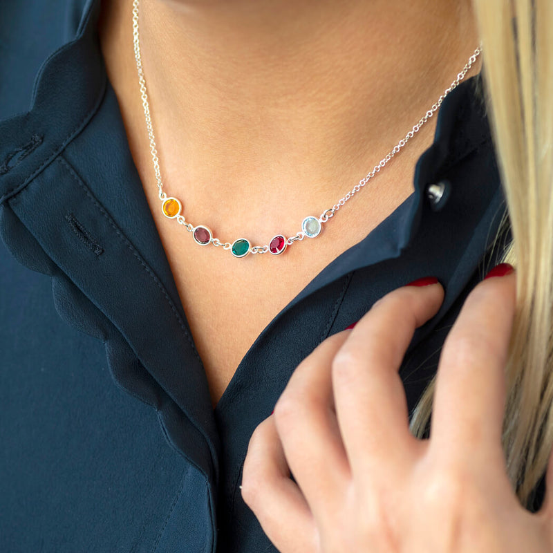 Model wears a silver Family Birthstone Link Necklace with five Swarovski Birthstone Crystals; yellow topaz, purple amethyst, green emerald, re garnet and aquamarine to represent the birth months November, February, May, January and March.