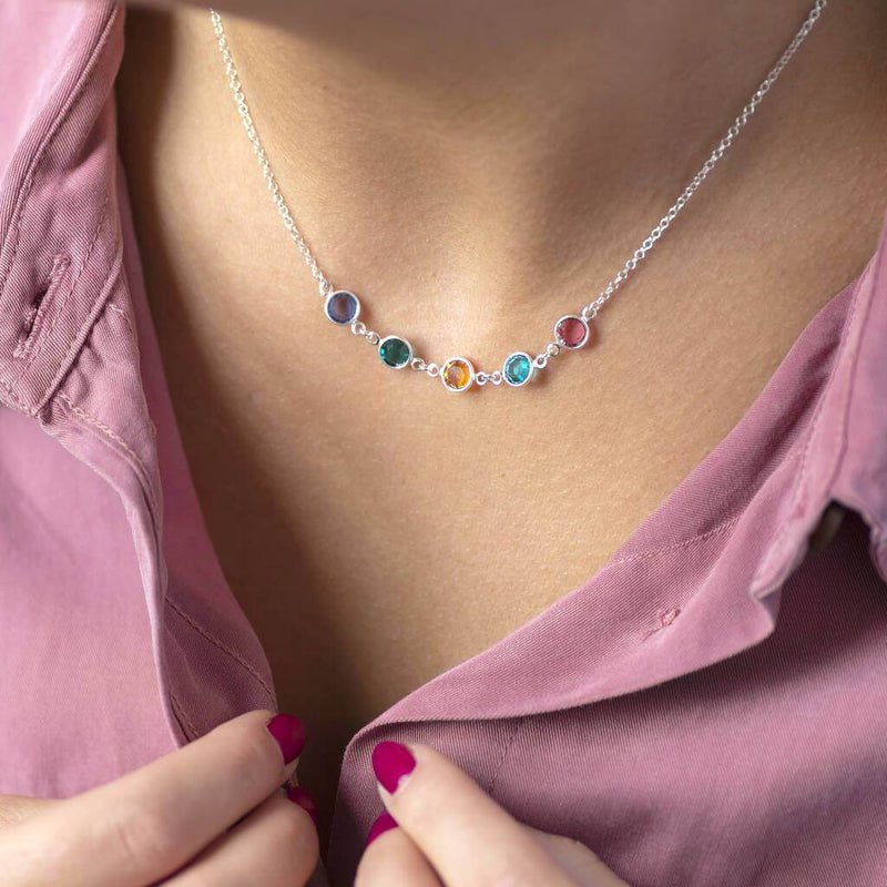 Model wears a silver Family Birthstone Link Necklace with five Swarovski Birthstone Crystals; purple amethyst, green emerald, yellow topaz, aquamarine and pink rose to represent the birth months February, May, November, March and October.