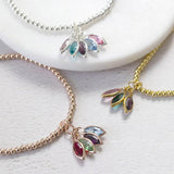 Image shows from top; silver plated family marquise style birthstone bracelet with June light amethyst, December blue zircon, February amethyst, March aquamarine and October rose swarovski birthstones. Rose gold plated bracelet with four marquise drop swarovski crystals from left to right in selection order: January Garnet, August Peridot, February Amethyst and March Aquamarine. Gold plated bracelet with october rose, may emerald and february amethyst birthstones. 