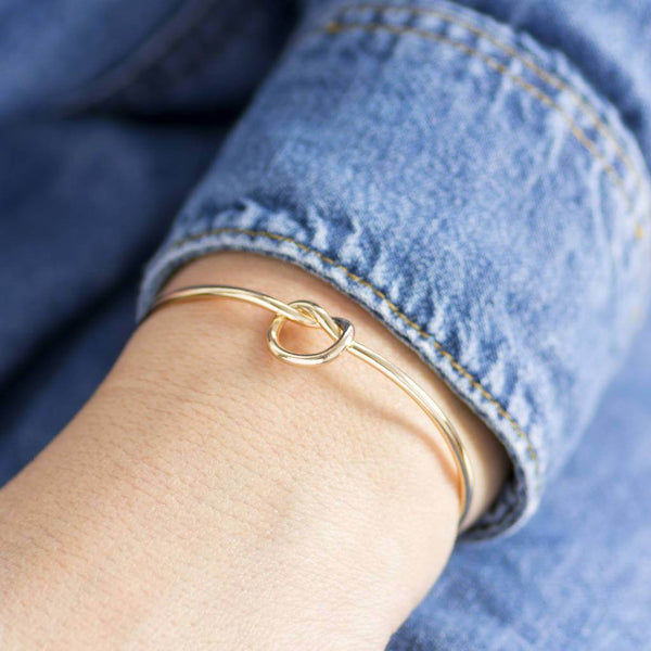Model wears gold plated Friendship Knot Bangle with no charms.