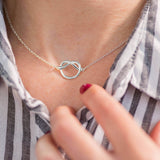 Model wears silver plated Friendship Knot Necklace.