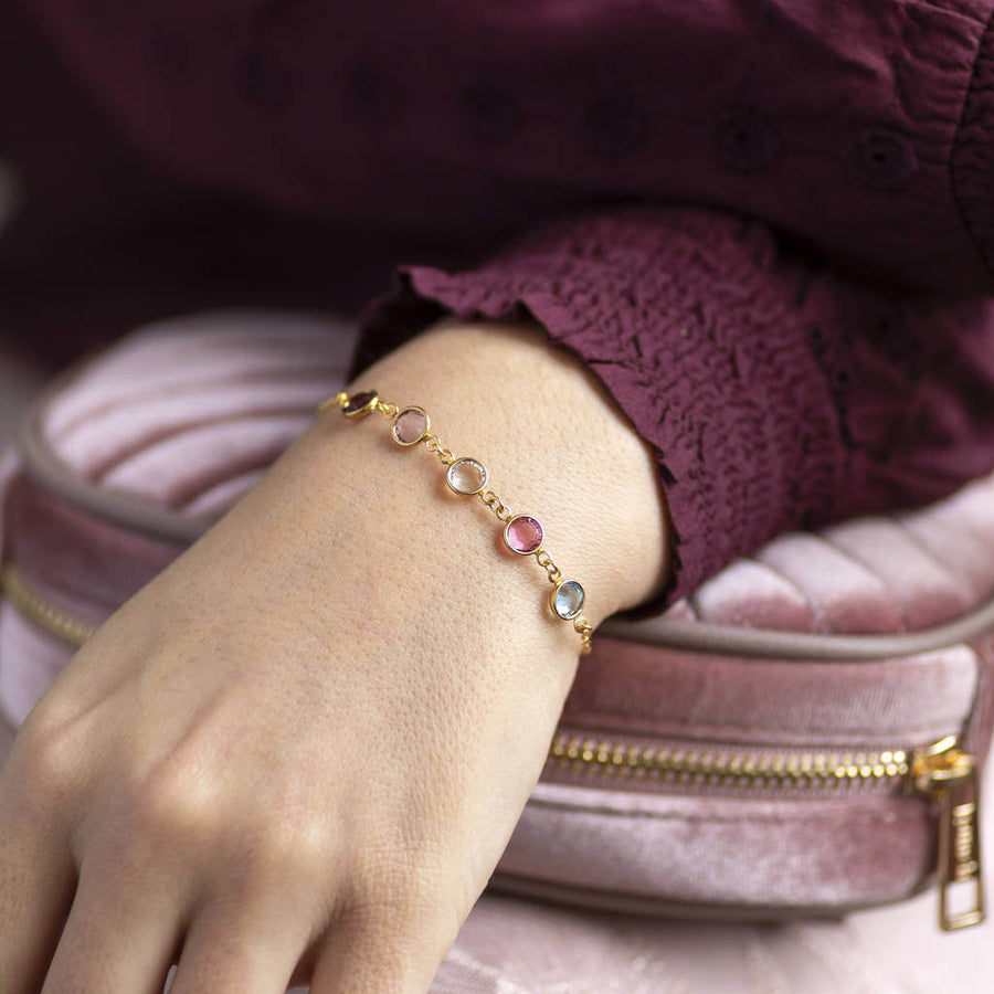 Model wear gold family swarovski birthstone link bracelet. Birthstones pictured from left to right: February Amethyst, June Light amethyst, April crystal, October rose and March aquamarine.