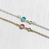 Image shows one sterling silver and one gold plated Three Generations Birthstone Bracelet sitting on a white background. Silver bracelet has December blue zircon birthstone and June light amethyst birthstone for the child. Gold bracelet shows October Rose for mother and March aquamarine for the child.