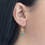 Model wears gold plated Mother and Child Birthstone Earrings with April crystal to represent child and December Blue Zircon to represent mother. Available in sterling silver.